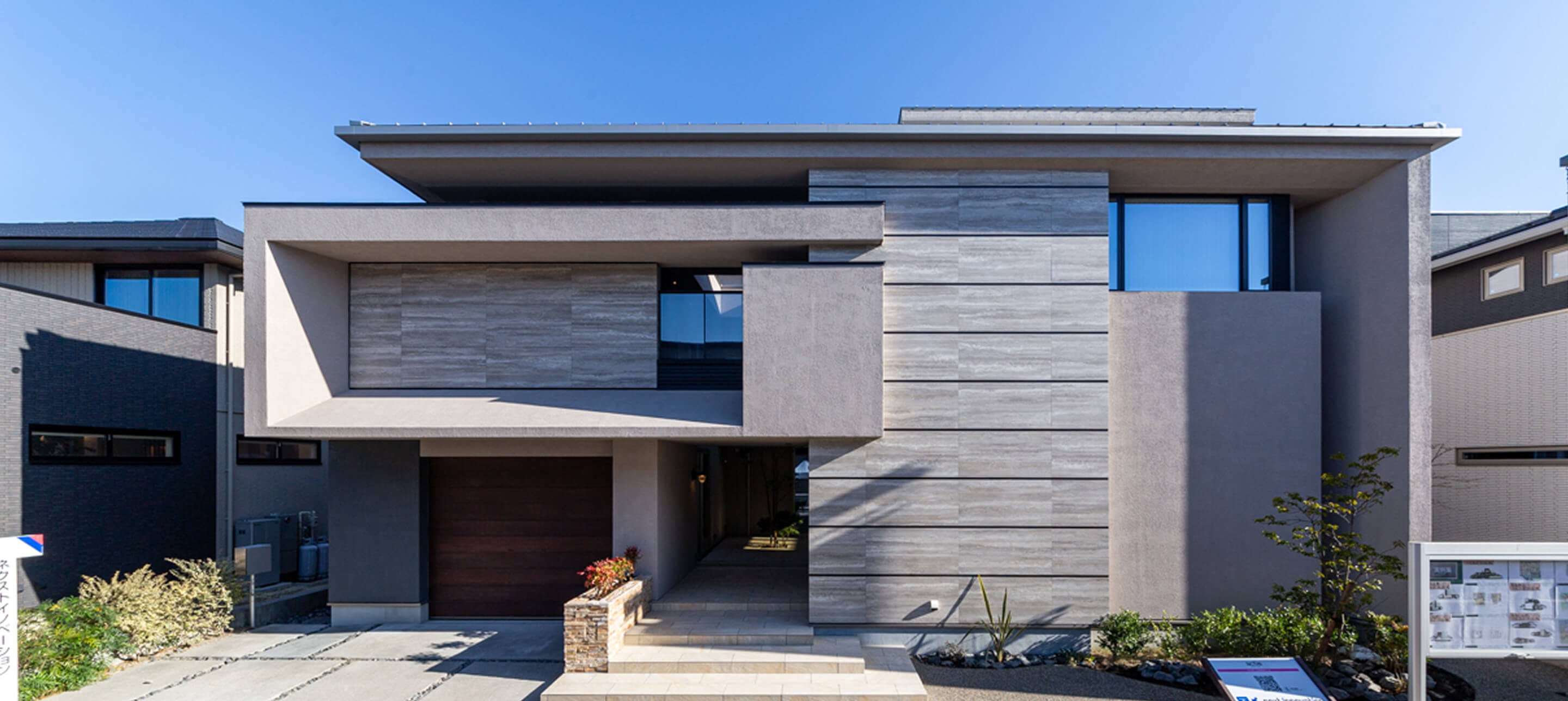 グレーと木目調を組み合わせた、重厚感のあるモダンデザインの二階建て注文住宅