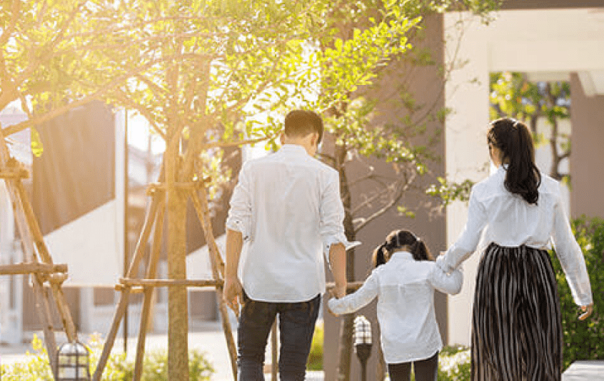 家族が手をつないで歩く様子。温かみのある光に包まれた日常のワンシーン