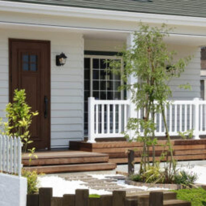 白い外壁とウッドデッキが特徴的な注文住宅の外観